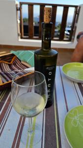 a bottle of wine and a glass on a table at Canto Rojo, La Asomada con vistas a Lobos in La Asomada
