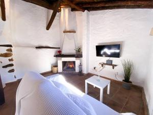 a living room with a couch and a fireplace at CasaBenadalid. Casa rural con piscina. in Benadalid