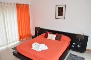 a bedroom with a bed with orange sheets and pillows at Foz Ocean Retreat in Foz do Arelho +6 photos