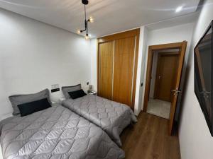 een slaapkamer met een bed en een televisie. bij Appt Haut Standing - Agadir Bay in Agadir +19 foto's