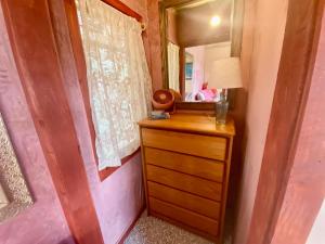 sypialnia z drewnianą komodą i lustrem w obiekcie Artsy Cabin on Organic Farm w mieście Naalehu