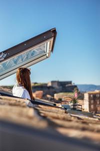 Una donna seduta su un autobus che guarda fuori dalla finestra di Vailato Loft Suites a Città di Corfù