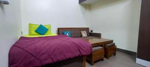 a small bedroom with a purple bed and a desk at Cozy 1bhk with Terrace. in Lucknow +12 photos
