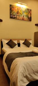 two beds in a hotel room with a painting on the wall at Cozy 1bhk with Terrace. in Lucknow