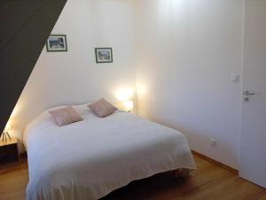 um quarto com uma cama branca e 2 almofadas em Gite Ferme du Marronnier em Graincourt