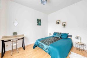 um quarto com uma cama azul e uma secretária em Paris Gentilly appartement tout équipé - RER B em Gentilly