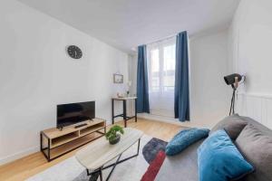 uma sala de estar com um sofá e uma televisão em Paris Gentilly appartement tout équipé - RER B em Gentilly