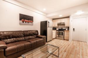 sala de estar con sofá de cuero marrón en la cocina en Cozy 1 bedroom apartment - 107, en Montreal