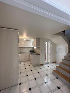 a kitchen with a staircase and a white tiled floor at Althea Old Town Apartment in Naxos Chora