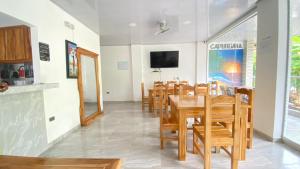 comedor con mesa y sillas en HOSTAL LAS FLORES, en Capurganá