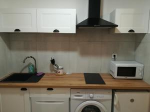 a kitchen with a sink and a microwave at Les jardins du Luxembourg in Hyères