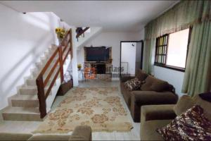 a living room with a couch and a tv at Casa de Campo de frente para belas montanhas in Extrema