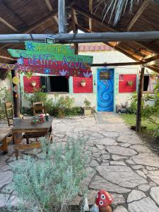 un patio con una mesa y un edificio con un cartel en Puerta Azul en Capilla del Monte