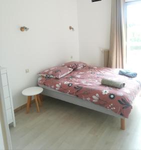 Schlafzimmer mit einem Bett, einem Tisch und einem Fenster in der Unterkunft Les jardins du Luxembourg in Hyères