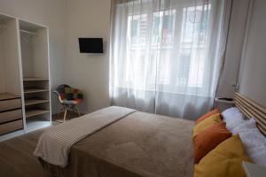 una camera con letto e finestra con sedia di Alda nella piazzetta in centro a La Spezia