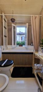 uma casa de banho com um WC e uma janela em The Cottage em San Maurizio dʼOpaglio