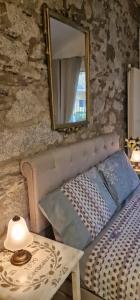 um espelho e uma cama num quarto com uma mesa em The Cottage em San Maurizio dʼOpaglio