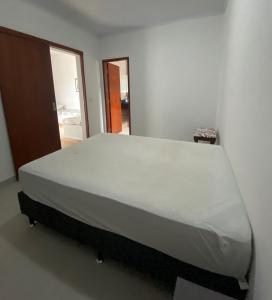 a large bed in a white room with a large mattress at Casa 2 Quartos 2 Suítes Castelhanos ES in Anchieta