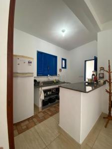 a kitchen with a refrigerator and a counter top at Casa 2 Quartos 2 Suítes Castelhanos ES in Anchieta