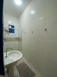 a white bathroom with a sink and a shower at Casa 2 Quartos 2 Suítes Castelhanos ES in Anchieta