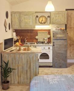 uma cozinha antiga com um fogão e um frigorífico em The Cottage em San Maurizio dʼOpaglio