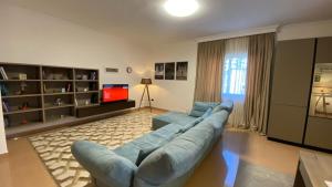 a living room with a blue couch and a television at Villa Chaplin in Tirana