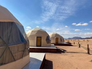 zwei gewölbte Zelte mitten in der Wüste in der Unterkunft Wejdan Rum Luxury Camp in Wadi Rum