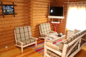a living room with two chairs and a tv at Boutigue Hotel Nebesa in Chimgan