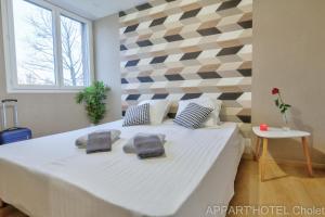 ein Schlafzimmer mit einem großen Bett mit zwei Handtüchern darauf in der Unterkunft Appart' hôtel Cholet in Cholet