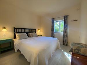 a bedroom with a large white bed and a window at Quinta da Cerejeira in Ferreira do Zêzere