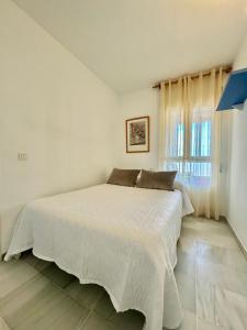 a white bed in a room with a window at Apartamento Arena y Sal in Torrox Costa