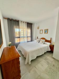 托羅克斯科斯塔的住宿－Apartamento Arena y Sal，一间卧室设有一张大床和一个窗户。