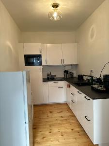 cocina con armarios blancos y nevera blanca en Cozy Apartment at Bergmannkiez en Berlín