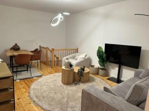 sala de estar con sofá, TV y mesa en Cozy Apartment at Bergmannkiez en Berlín
