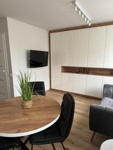 a dining room with a wooden table and black chairs at MW3 Apartament in Rzeszów