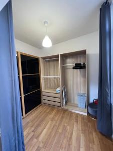 ein Wohnzimmer mit Holzböden und einem blauen Vorhang in der Unterkunft Maison Jehan-Séré in Tarascon-sur-Ariège