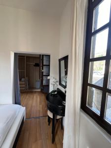 a bedroom with a desk and a bed and a mirror at Maison Jehan-Séré in Tarascon-sur-Ariège