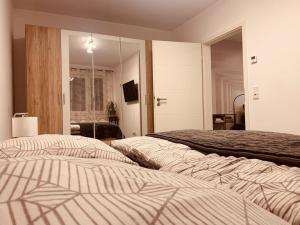 - une chambre avec 2 lits et un miroir dans l'établissement Apartment am Engelsblick - die Eifel direkt vor der Tür, à Kreuzau
