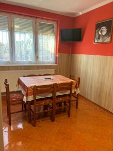 comedor con mesa, sillas y TV en Horvath Vendeghaz, en Hegyeshalom