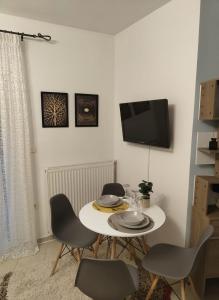 een eetkamer met een tafel en stoelen en een tv bij Καταλύματα ως ολόκληρος χώρος. Οικοδεσπότης: Νίκος in Florina