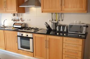 a kitchen with wooden cabinets and a stove top oven at Foz Ocean Retreat in Foz do Arelho