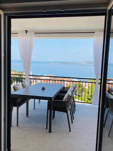 a dining table on a balcony with a view of the ocean at Baltimore.House in Baška Voda