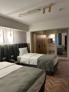 een hotelkamer met 2 bedden en een bank bij Iris Han Hotel in Istanbul