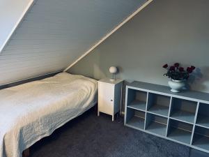 Un dormitorio con una cama y una mesa con un jarrón de flores en Stort og flott hus på Tyholt, en Trondheim