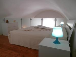 マテーラにあるCasa Vacanza Martinoのベッドルーム1室(ベッド1台、ドレッサーの青いランプ付)