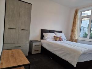 ein Schlafzimmer mit einem Bett mit einem Teddybär drauf in der Unterkunft Radiant Accommodation Manor Lane in Plymouth