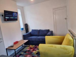 a living room with a blue couch and a table at Radiant Accommodation Manor Lane in Plymouth