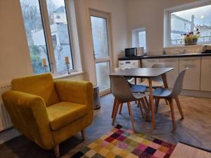 een woonkamer met een tafel en stoelen en een stoel bij Radiant Accommodation Manor Lane in Plymouth