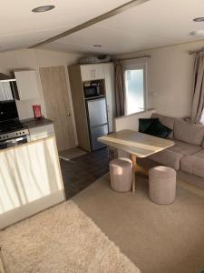 a kitchen and living room with a table and a couch at Lemon Grove in Mudeford