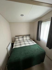 a bedroom with a green bed in a small room at Lemon Grove in Mudeford